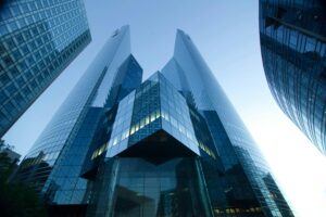 Low-angle view of modern glass skyscrapers reflecting a clear blue sky. Perfect for urban and architectural themes.